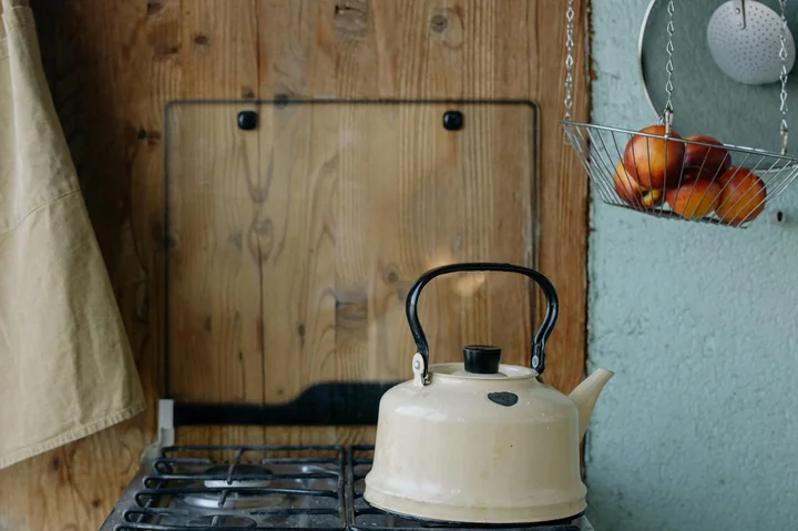 Obrazek przedstawia czajnik położony na kuchence gazowej