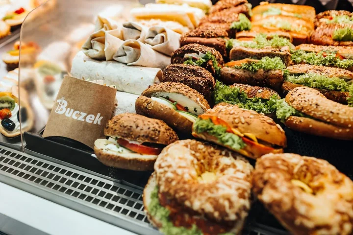 Na obrazku widać kanapki m. in. z sałatą i pomidorem od firmy Buczek