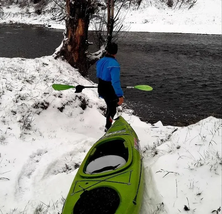 Mężczyzna z kajakiem przygotowujący się do spływu Dunajcem zimą