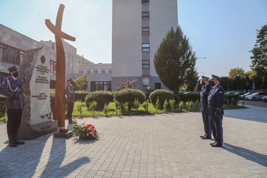 Policjanci oddają honory pod krzyżem znajdującym się na terenie KWP w Krakowie