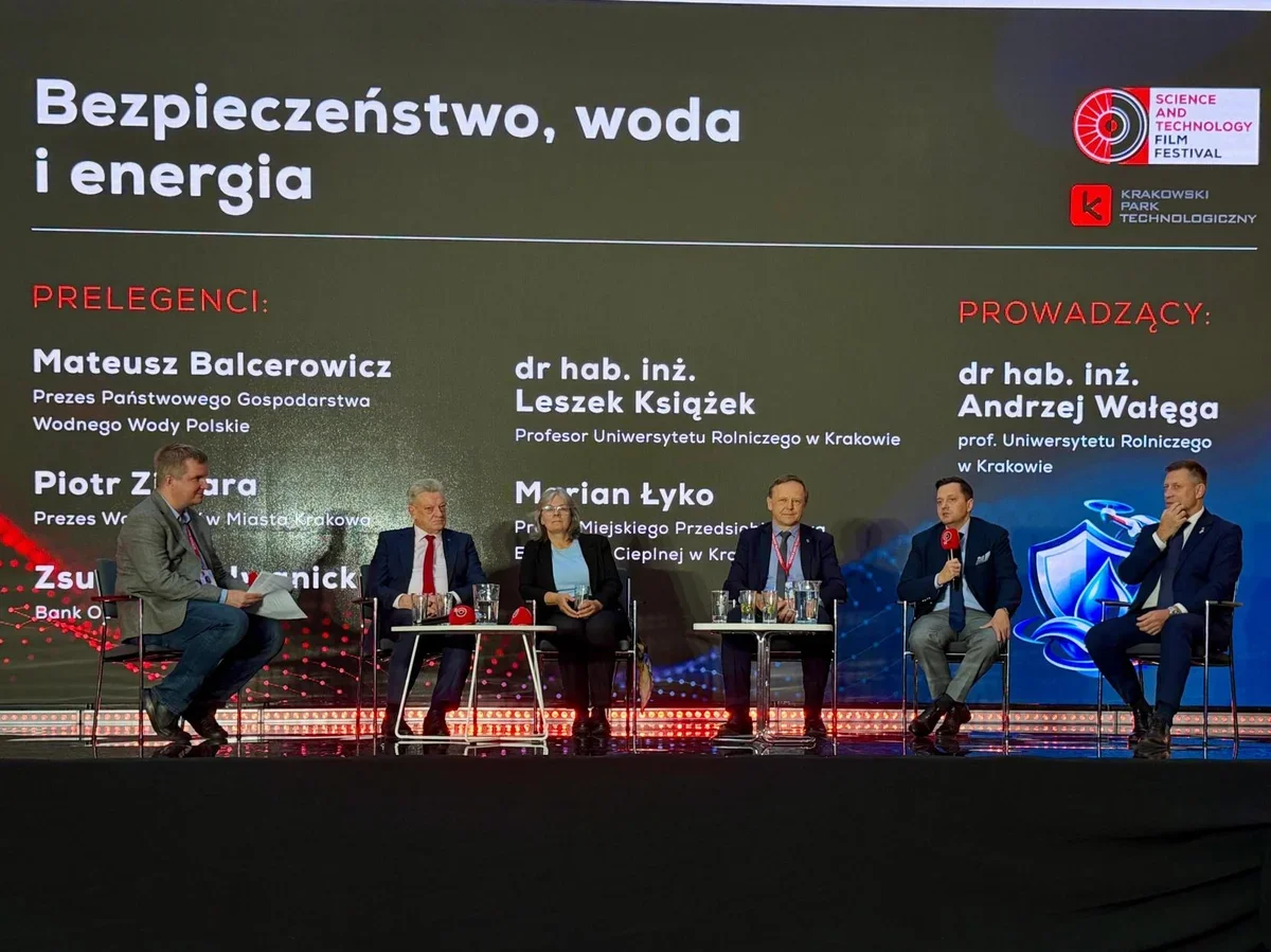 Panel dyskusyjny pt. „Bezpieczeństwo, woda i energia” podczas Science and Technology Film Festival w Krakowie, z udziałem prelegentów i prowadzącego na scenie.