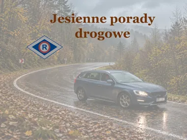 Samochód osobowy jedzie po mokrej, zakręconej leśnej drodze pokrytej opadłymi liśćmi w deszczowy jesienny dzień.