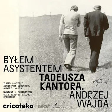 Dwie osoby odwrócone plecami do obiektywu wędrują ścieżką przez trawiaste wzgórze.