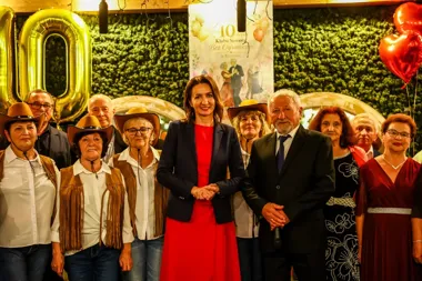 Grupa osób, w tym uczestnicy klubu seniora w kowbojskich strojach, pozuje podczas jubileuszu 10-lecia Klubu Seniora Bez Ograniczeń w Rzeszowie.