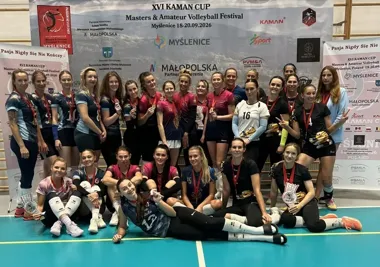 Uczestniczki XVI KAMAN CUP – Masters & Amateur Volleyball Festival w Myślenicach pozują do pamiątkowego zdjęcia z medalami na tle baneru turniejowego.